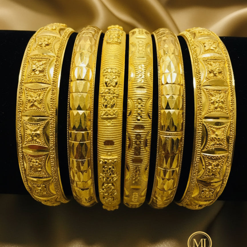 A set of gold-colored bangles with intricate filigree and cutwork, displaying a matte finish.